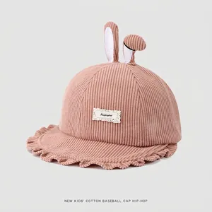 Détail chapeau bob enfant en velours rose avec oreilles de lapin et étiquette dentelle