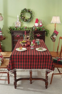 Close-up of red and green plaid Christmas tablecloth with white fringe tassels