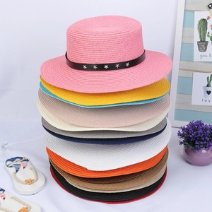 Detailed pile of colorful straw sun hats with star-studded leather bands and flat brims