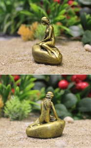 Detalle de la escultura de sirena con acabado en bronce y escamas de cola talladas