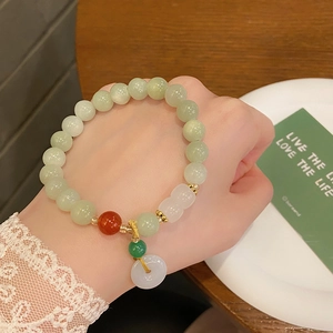 Bracciale artistico in giada da 8mm con fibbia della pace bianca su tavolo di legno