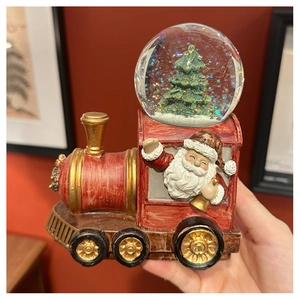 Detail of Santa Claus train snow globe featuring glitter flakes and festive resin finish