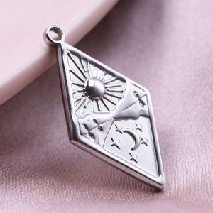 Macro shot of silver diamond-shaped stainless steel pendant with sun moon and star motifs