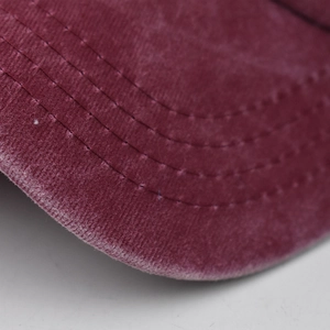 Close-up of wine red baseball cap showing premium corduroy texture and curved stitching