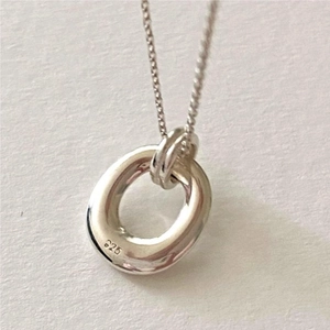 Macro shot of the polished 925 sterling silver ring pendant on a delicate cross chain