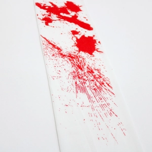 Close-up of Halloween white fabric bandage with realistic red blood splatter prints
