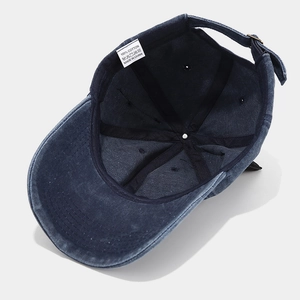 Detail view of cotton baseball cap interior with stitching and metal adjustment buckle