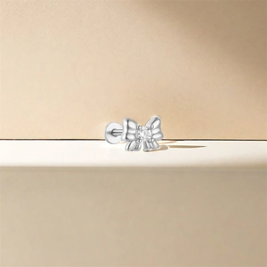 Detail of 925 silver bow stud earring with a central clear cubic zirconia stone