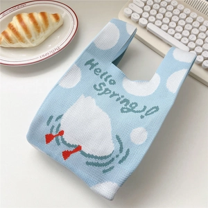 Close-up of a blue knitted handbag featuring Hello Spring text and a cute cartoon design