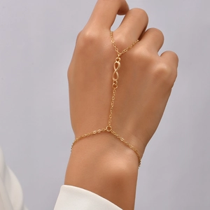 Detail of gold chain hand bracelet featuring infinity symbol design on hand