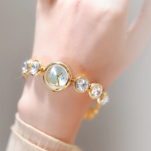 Montre élégante pour femme en or champagne avec bracelet en strass sur le poignet