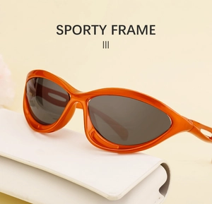 Detail view of sporty orange polarized sunglasses frame on a warm beige background