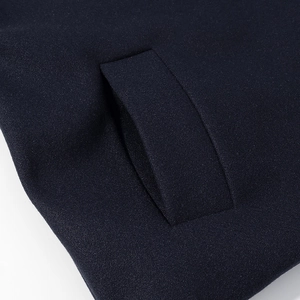 Detail of dark blue jacket pocket highlighting polyester fabric texture and stitching
