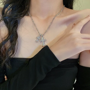 Silver cross necklace with sparkling rhinestones on a model for a chic layered look