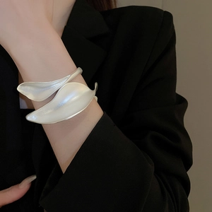 Macro shot of matte silver leaf-shaped open cuff bracelet in artistic metal design