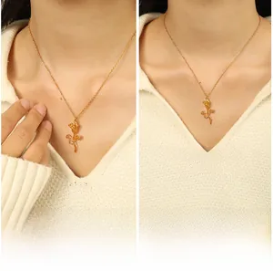 Close-up of golden rose pendant necklace on model with beige sweater background