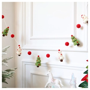 Close-up of handmade wool felt Christmas garland with green trees and red balls