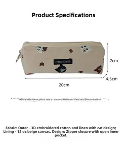 Detail of embroidered cat pattern on beige canvas pencil case with zipper and logo label