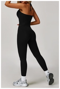 Detail of black halter crop top and high waist yoga leggings with compression fabric