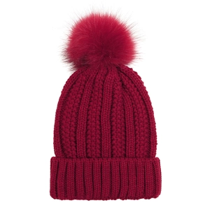 Close-up of deep red knit beanie featuring a large faux fur pom-pom and ribbed texture
