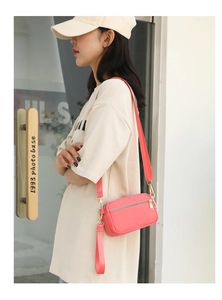 Detail of hot pink nylon crossbody bag with adjustable wide strap and gold hardware