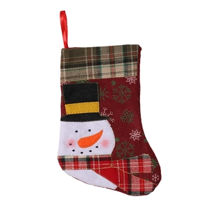 Christmas stocking with snowman embroidery and red plaid cuff on a white background