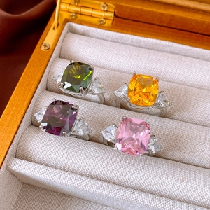 Macro shot of rectangular zircon rings in green orange purple and pink in a velvet box