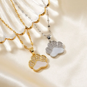 Elegant gold and silver bear paw necklaces with zircon inlay on cream silk background