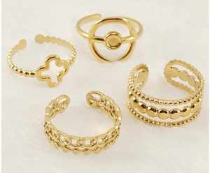 Detailed view of four adjustable 18K gold-plated clover and beaded stackable rings