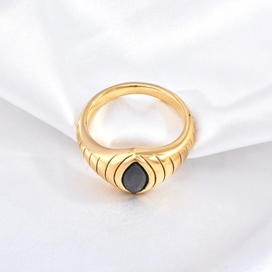 Detailed macro view of gold plated eye ring with black marquise zircon on white silk
