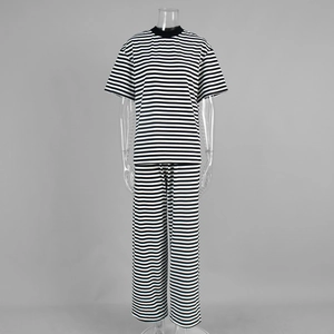 Dettaglio del tessuto a righe bianche e nere sui pantaloni larghi e il set di magliette