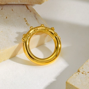 Detailed close-up of a gold ring with raised dotted texture on stone display
