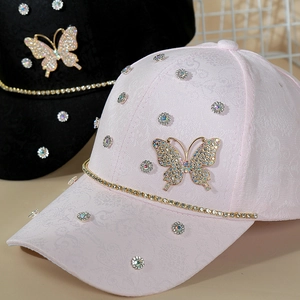 Macro view of sparkly rhinestone butterfly and crystal accents on a pink baseball cap