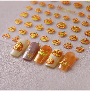 Close-up of Halloween pumpkin nail art stickers with metallic polarized finish and patterns