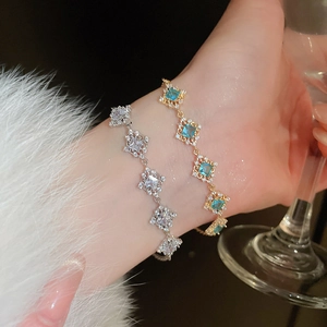 Detail of luxury geometric square blue zircon bracelet on model wrist with glass