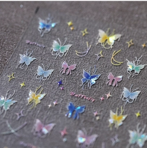 Macro detail of holographic butterfly nail stickers with gold foil and laser bow designs