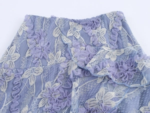 Détail de jupe en tulle bleu violet avec broderie blanche et dentelle florale 3D