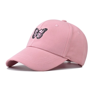 Gros plan détaillé de la casquette de baseball en coton rose avec broderie papillon