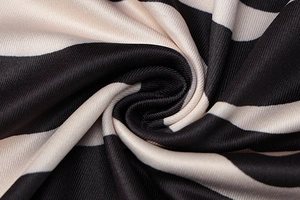 Gros plan sur la texture du tricot à rayures noir et crème montrant le drapé doux