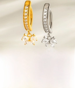 Detailed view of titanium bowknot navel rings with heart zircon in gold and silver