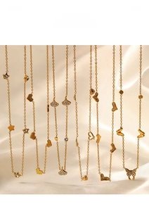 Detail of gold-plated necklaces with heart, star, and butterfly pendants on silk fabric