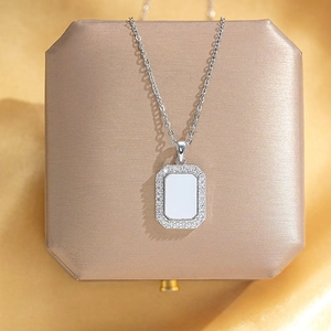 Detail of silver geometric rectangular pendant with sparkling pave crystals on jewelry box