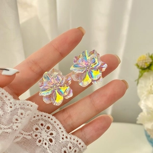 Macro view of iridescent aurora flower earrings with multi-color shimmering petals