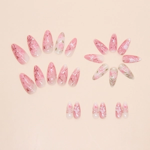 Detail of almond-shaped pink gradient press-on nails with 3D pearls and floral designs
