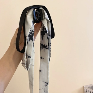 Detail of large black hair claw clip with silk ribbon in artistic ink-wash pattern