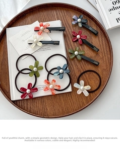 Detailed set of floral acetate hair clips and elastics with pearls on wooden tray
