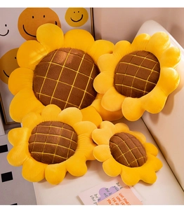 Detail showing plush sunflower cushions in four sizes on a soft white leather sofa