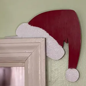 Detail view of Santa hat wooden door corner decoration on a white frame