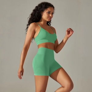 Side view of seamless mint green sports bra and high-waisted shorts on a model