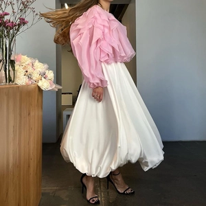 Detail van roze top met ruches en witte volumineuze pofrok op een model gepresenteerd